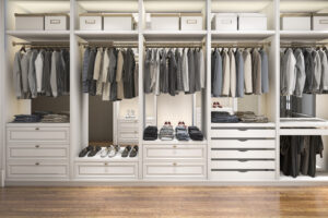Elegant walk-in closet with neatly organized clothes and shoes.