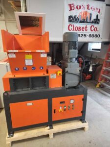 Orange and gray industrial machine Boston Closet Co uses for wood waste management